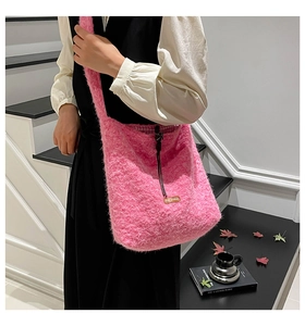Detail of soft pink plush tote bag with black drawstring and star picking leather tag