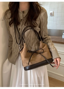 Detail of retro minimalist large tote with suede texture and leather bow tie detail