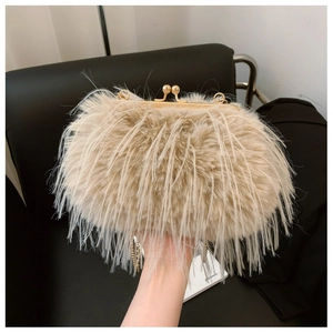 Detail of beige turkey feather clutch with vintage gold clasp and delicate chain strap