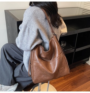 Side view of brown large tote bag showing hobo style texture and side pocket