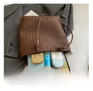 Détails de l'intérieur du sac tissé marron montrant un grand espace de rangement utile