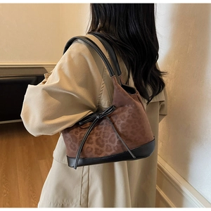 Dettaglio borsa a spalla leopardata con rifiniture in pelle nera e fiocco chic