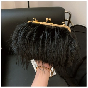 Detail view of black faux fur bag with golden metal frame and round ball clasp