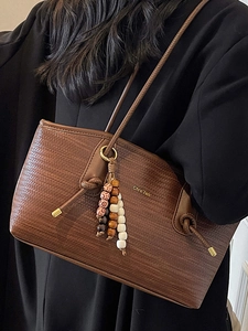 Chic brown woven leather tote bag for women with wooden bead charm and shoulder strap
