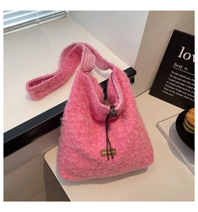 Detail of pink plush crossbody bag featuring checkered lining and drawstring closure