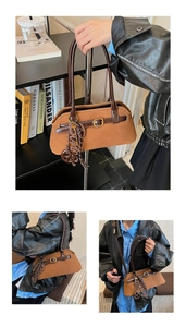 Detail view of a vintage brown suede bowling bag with leather straps and metal buckle