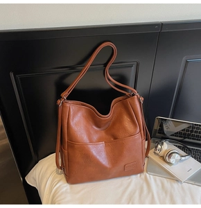 Detailed view of caramel brown tote bag with large front pockets and office essentials