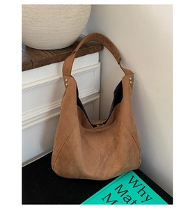 Detail view of the brown suede hobo bag featuring silver rivets and large capacity