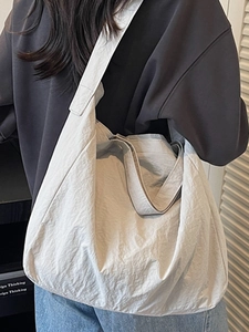 Large beige commuter tote bag with soft pleated fabric and wide strap for daily use