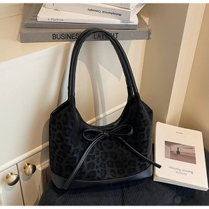 Dettaglio borsa a secchiello leopardata con base in pelle e fiocco decorativo