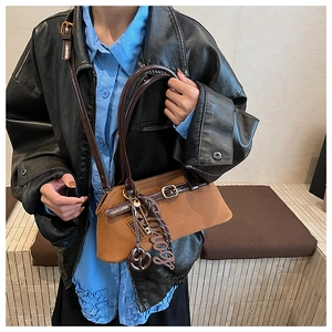 Detail of vintage brown suede tote bag with leather straps and metal buckle accents