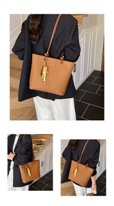 Détail d'un sac cabas marron tissé avec pompon en perles et longue bandoulière nouée