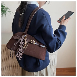 Brown suede underarm bag detail with belt buckle decoration and slim shoulder straps
