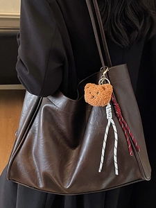 Retro brown faux leather tote bag with plush bear charm and woven cords for office commute