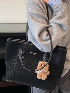 Large black leopard jacquard tote bag with golden logo and plush bear pendant detail