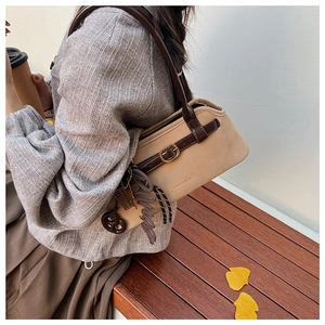 Detail of khaki suede tote bag with brown leather straps and vintage metallic buckle