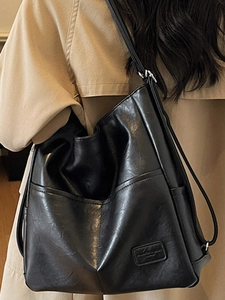 Classic black high-capacity tote bag in polished faux leather for female commuters