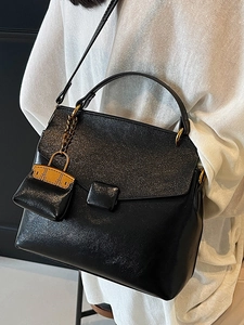 Elegant black minimalist crossbody handbag with gold hardware and stylish leather texture