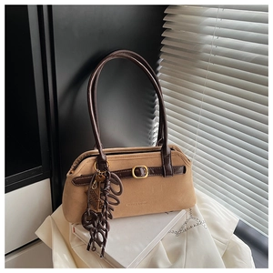 Close-up of khaki suede tote bag with brown leather straps and metal hardware details
