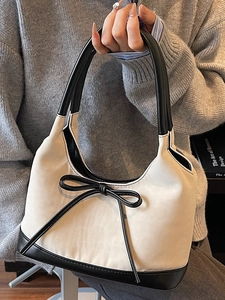 Elegante borsa a secchiello in camoscio bianco con finiture in pelle nera e fiocco