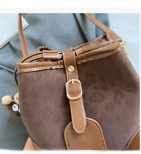 Detail of dark brown bucket bag featuring lychee grain leather and plush eye charm