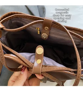 Detail view of the brown bucket bag showing interior magnetic clasp and zipper pocket