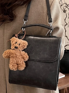 Retro black leather backpack with embossed letters and plush bear charm for autumn style
