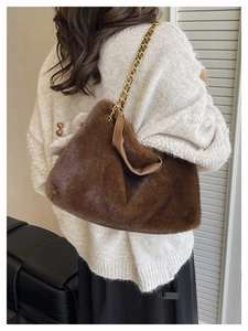 Détail du sac à bandoulière en fausse fourrure marron foncé avec chaîne dorée chic
