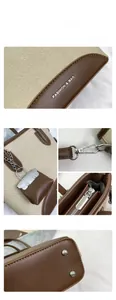 Detailed view of beige canvas and brown leather bucket bag with silver metal hardware