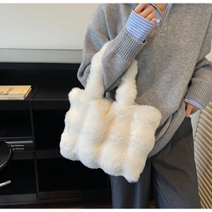 Détail montrant la texture en fausse fourrure blanche d'un sac cabas d'hiver élégant