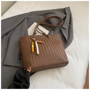 Detailed macro view of deep brown woven texture on a tote bag with beaded tassel