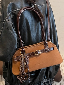 Brown faux suede underarm tote bag with leather straps and decorative metallic buckle