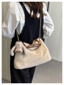 Détail du sac à main en peluche blanc cassé avec breloque lapin et chaîne dorée
