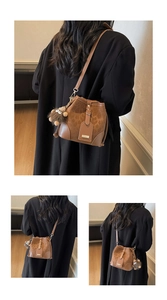 Detail of vintage brown bucket bag with monogram pattern and plush bear charm pendant