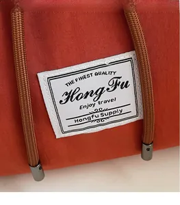 Detail of high-density canvas backpack with braided ropes and metal tips