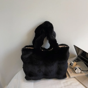 Gros plan sur un cabas noir en fausse fourrure avec ordinateur portable et casque