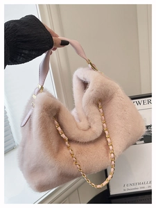 Détail d'un sac cabas en peluche rose clair avec chaîne dorée et texture douce et moelleuse