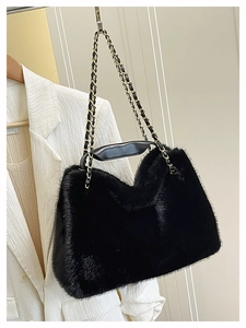 Détail du sac fourre-tout en fausse fourrure noire avec chaîne dorée et bandoulière