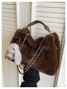 Détail d'un sac à main en peluche marron foncé avec poignée en cuir et lapin gris
