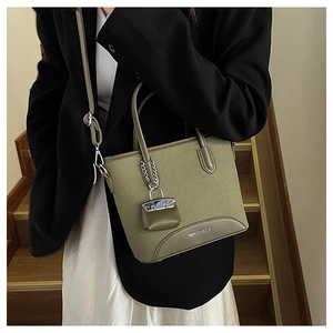 Detail view of moss green canvas bucket bag with leather trim and mini pouch accessory