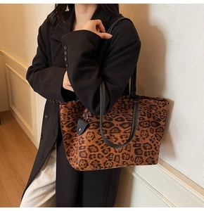 Vue détaillée du sac cabas en daim imprimé léopard avec bandoulière noire porté par un mannequin