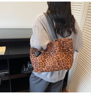 Détail du sac cabas léopard avec bandoulière noire porté par un mannequin en intérieur