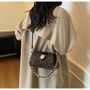 Détail du sac à main léopard avec chaîne argentée porté sur un trench-coat chic