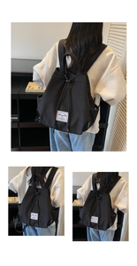 Close-up of black canvas backpack with bucket shape, drawstring closure and label