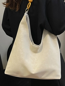Minimalist beige hobo tote bag with unique yellow bead and gold ring shoulder strap