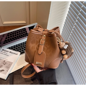 Brown bucket bag with leopard print and a cute plush monster charm detail