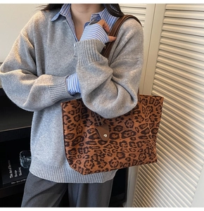 Détail d'un grand sac fourre-tout léopard en daim avec bandoulière marron sur le mannequin