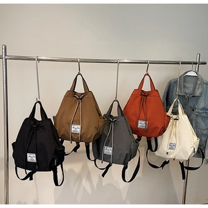 Detailed display of casual canvas backpacks in five colors on a stainless steel rack