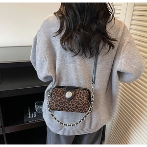 Détail du sac bandoulière léopard avec bandoulière chaîne argentée et boucle en métal
