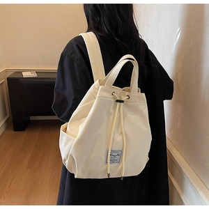 Detail of off-white canvas backpack featuring drawstring closure and CongFu brand logo